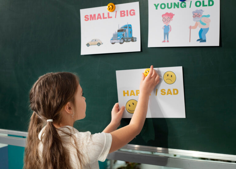 Menina colando cartazes com palavras em inglês em um quadro. Aprender inglês na infância.